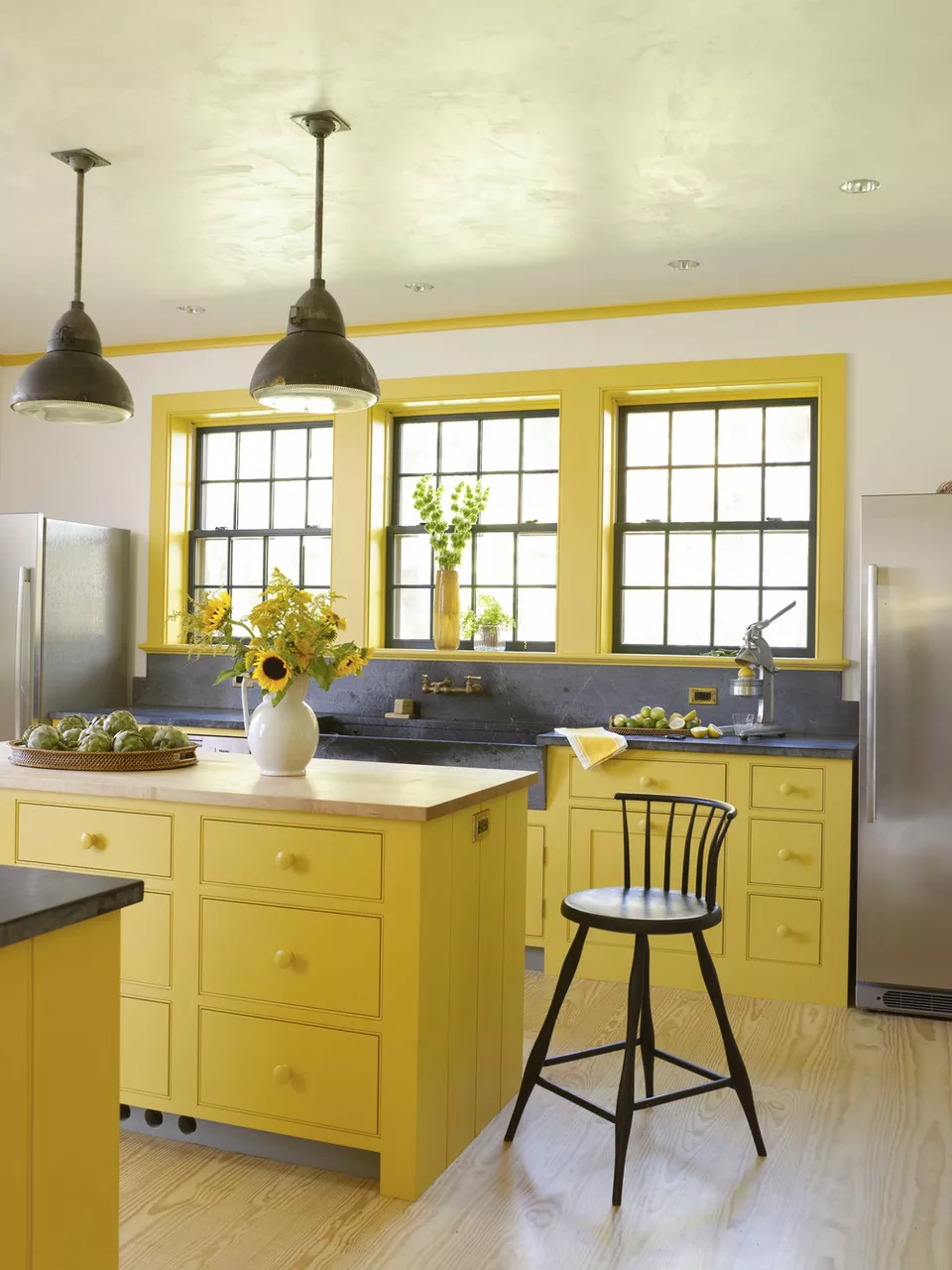 nhà bếp màu vàng với mặt bàn bằng đá xà phòng